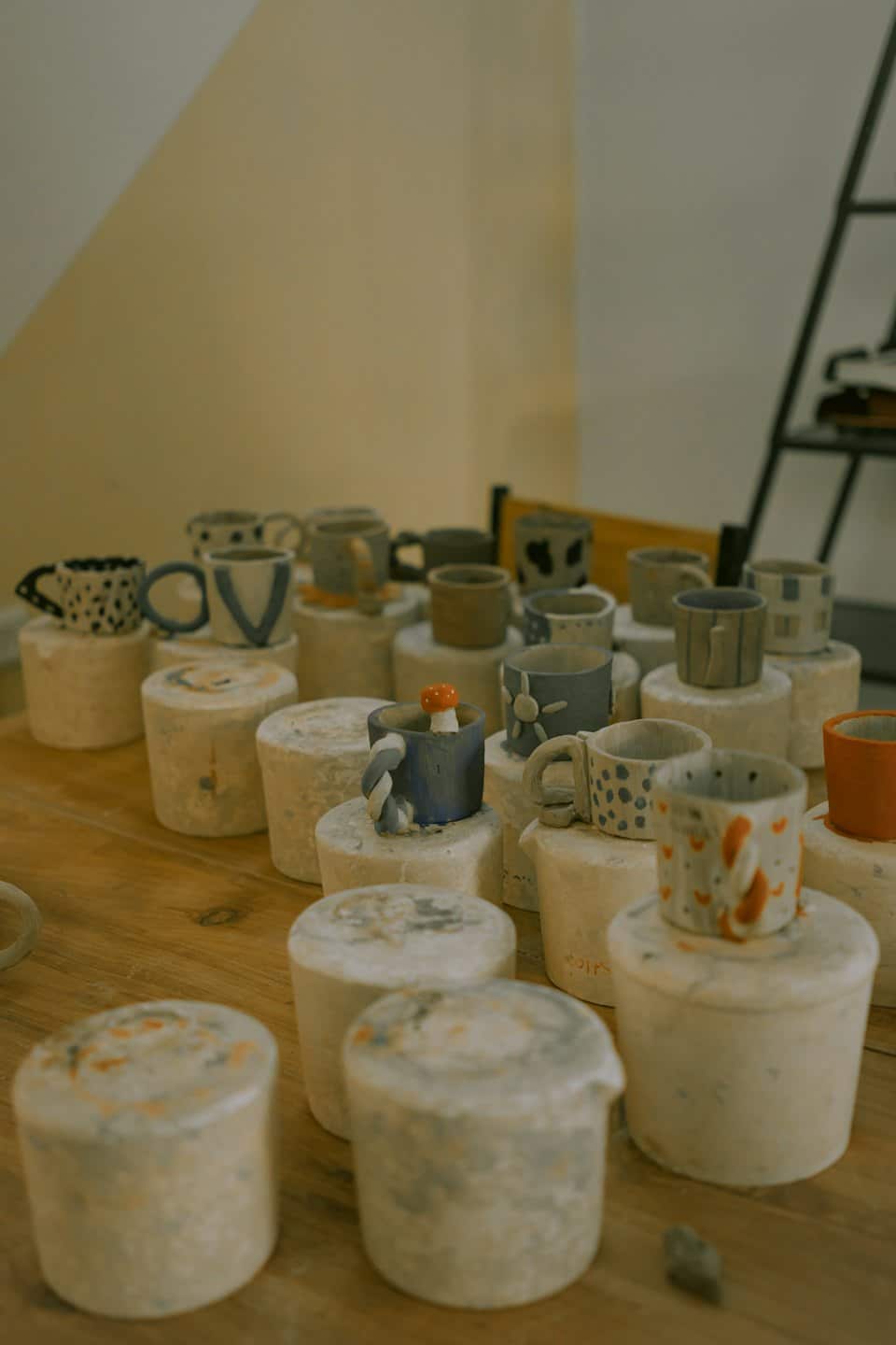 Tazze e tazzine in ceramica artigianale su tavolo di legno.